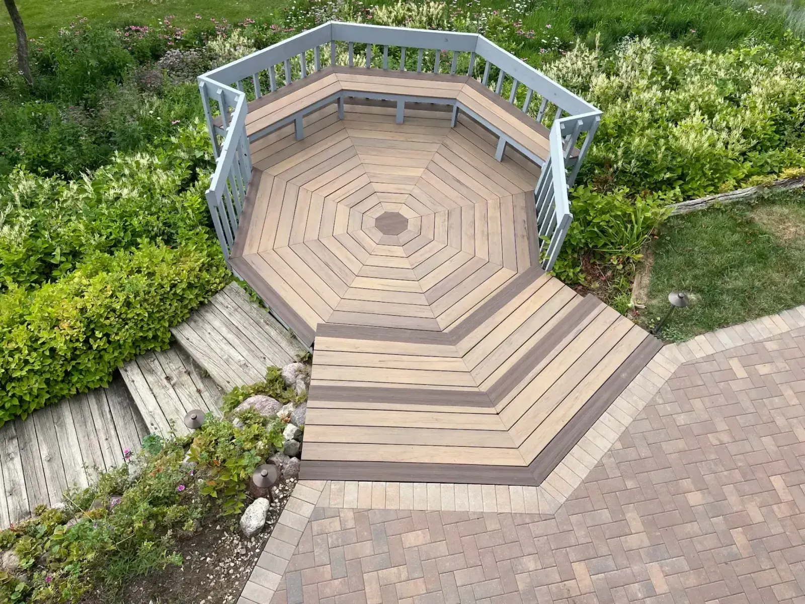 Aerial view of composite deck meeting Unilock paver patio border