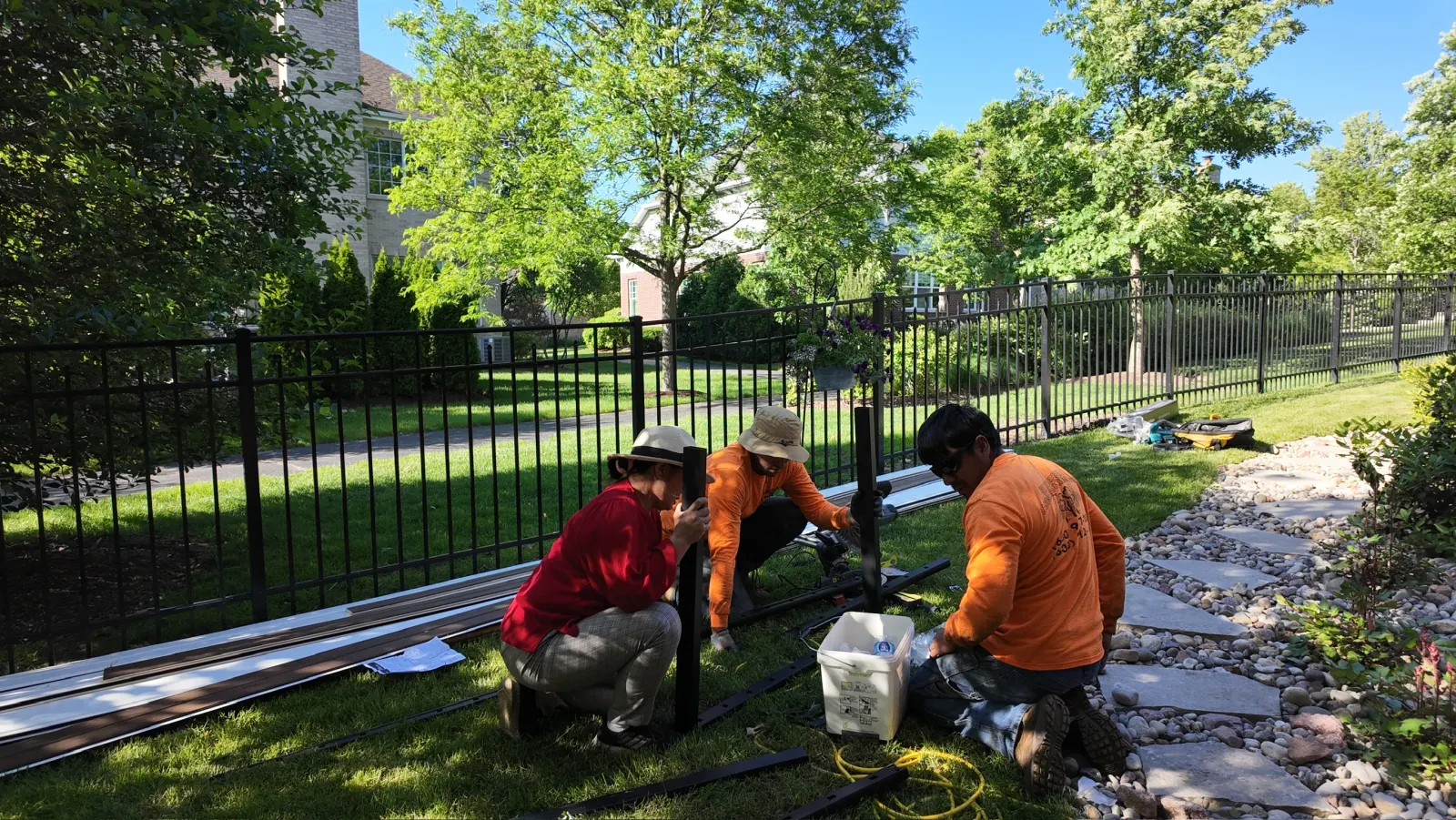 Smith Brothers crew installing black aluminum fence in residential yard